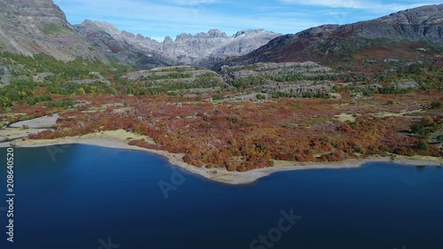 Epu Lauquen lagoons in autumn, big rocky mountains of the Andes at background. Aerial drone scene moving forward towards a waterfall and river in the mountains. Neuquen, Patagonia Argentina. photo