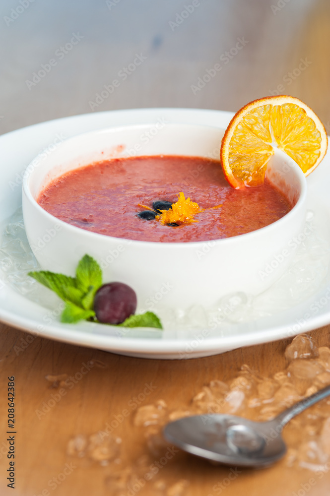 Side view - berry-fruit mousse served in bowl with an orange slice of berries and mint and ice slices. Dessert of the restaurant Side view - berry-fruit mousse served in bowl with an orange slice of berries and mint and ice slices. Dessert of the restaurant