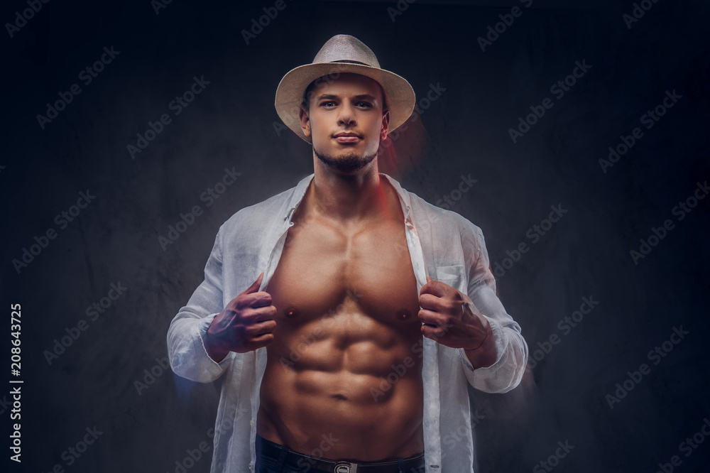 Portrait of a sexy handsome guy with muscular body in an unbuttoned white  shirt and panama hat. Stock Photo | Adobe Stock