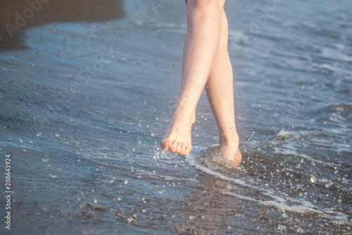 Closeup of a female's bare feet walking at a beach. Concept of the travel, vacation © k_samurkas