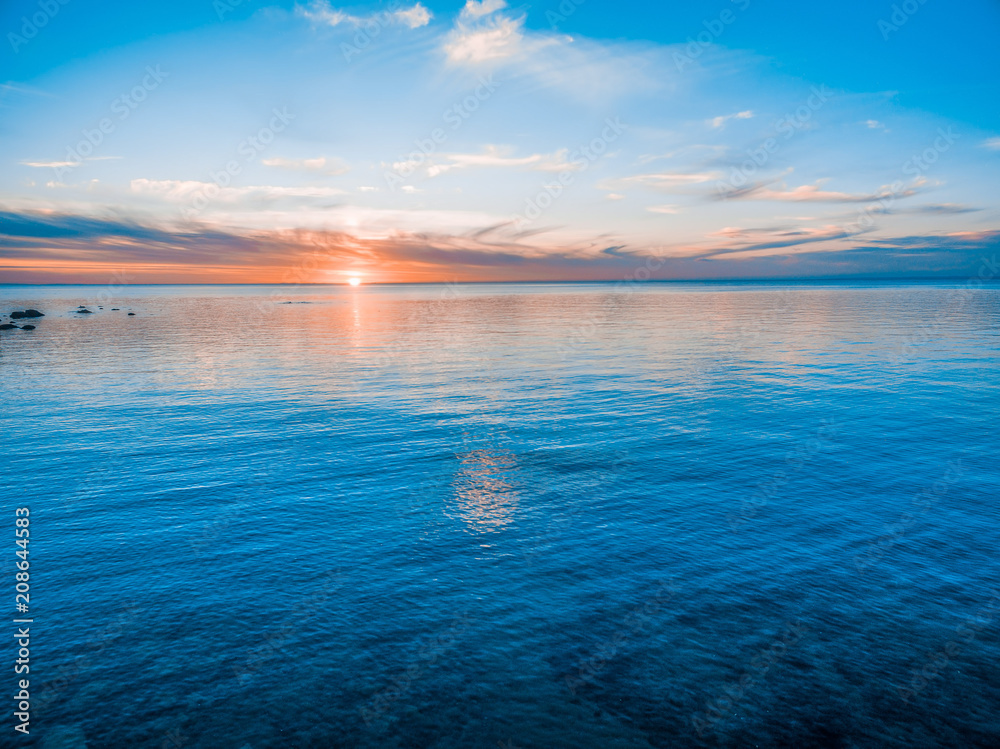 Sun touching calm water - seascape sunset
