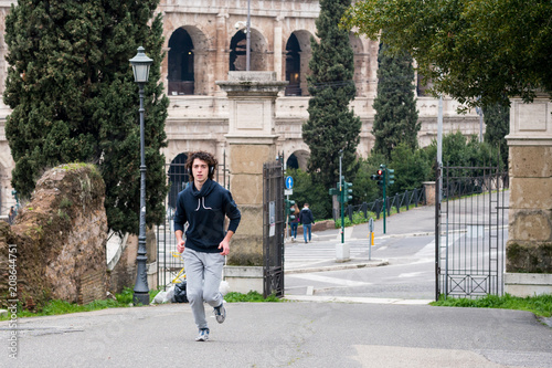 Canvas Print Handsome young sportsman jogging in park in Rome city