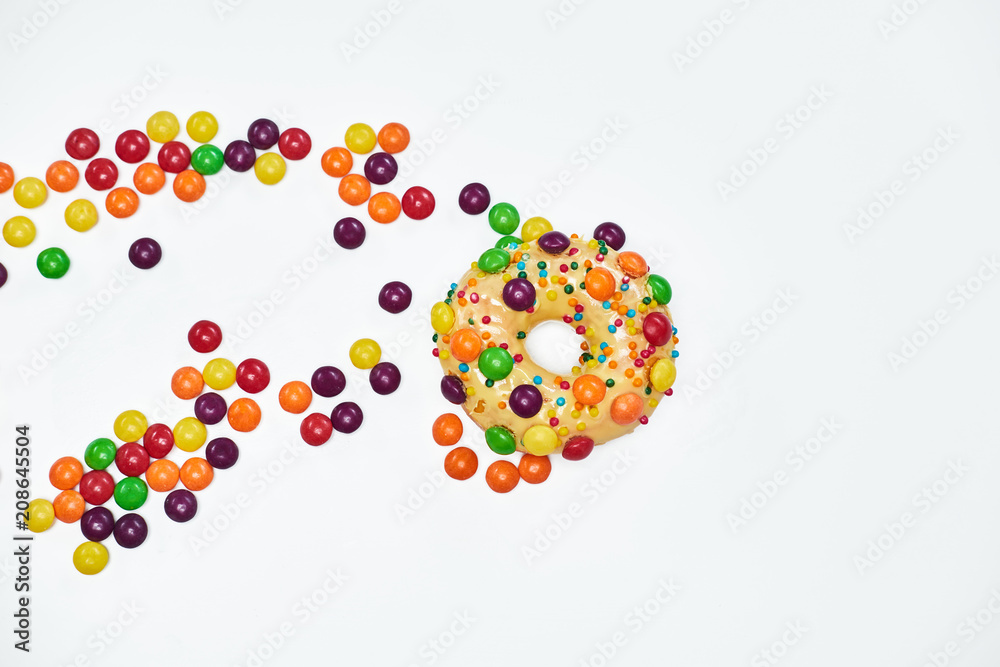 Appetizing golden donut sprinkled with colorful chocolate pellets. Appetizing golden donut sprinkled with colorful chocolate pellets.