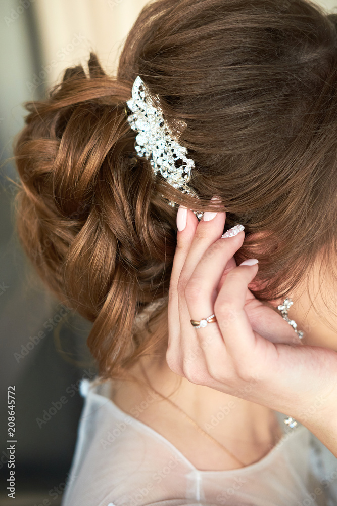 bride fastens the barrette in her hair