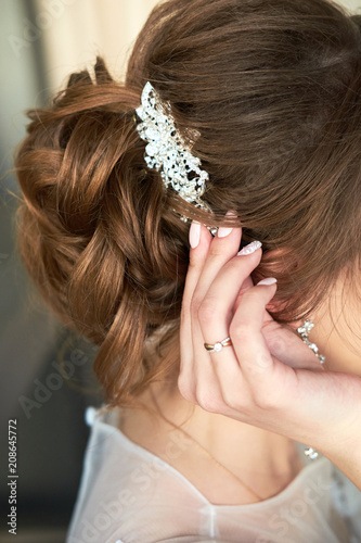 bride fastens the barrette in her hair