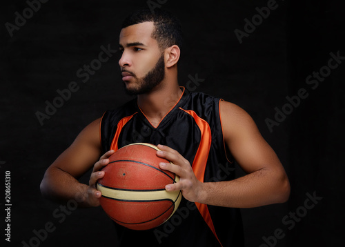 Portrait of an Afro-American sportsman. Basketball player in sportswear with a ball © Fxquadro