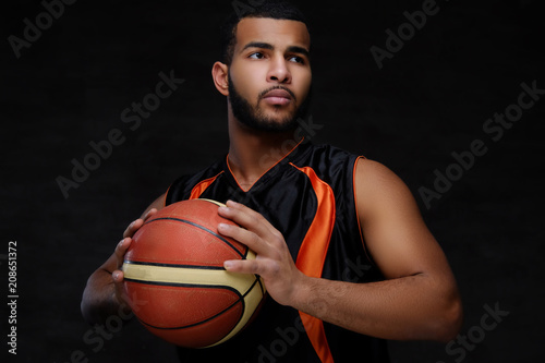 Portrait of an Afro-American sportsman. Basketball player in sportswear with a ball © Fxquadro