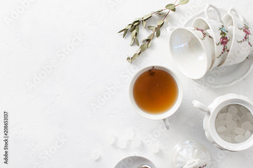 Tea in a Cup with dry flowers on a white table. Copy space text