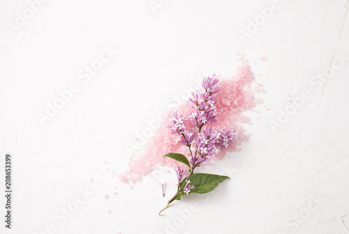 Scattered pink salt with flowers on white.