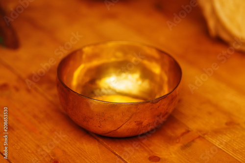 beautiful tibetian bowl with golden light reflections. photo