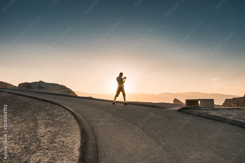 Man taking picture during sunset in the lowest point on earth in Death valley, USA, West Coast Man taking picture during sunset in the lowest point on earth in Death valley, USA, West Coast