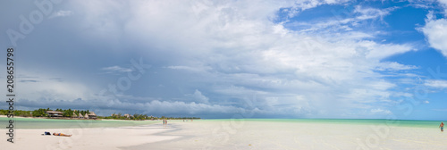 HOLBOX  MEXICO - MAY 22  2018  Panaoramic view of tourists walking the beach at Holbox Island while a storm passes through