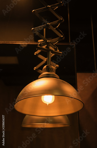 Lamp bulb with light on the ceiling and a selection with black background
