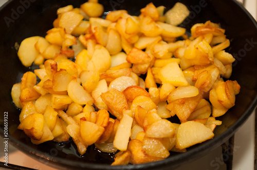 Fried potatoes on black frying pan