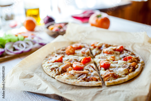 hot fresh homemade traditional italian pizza on wooden table. wallpaper for pizzeria and cooking food concept. closeup