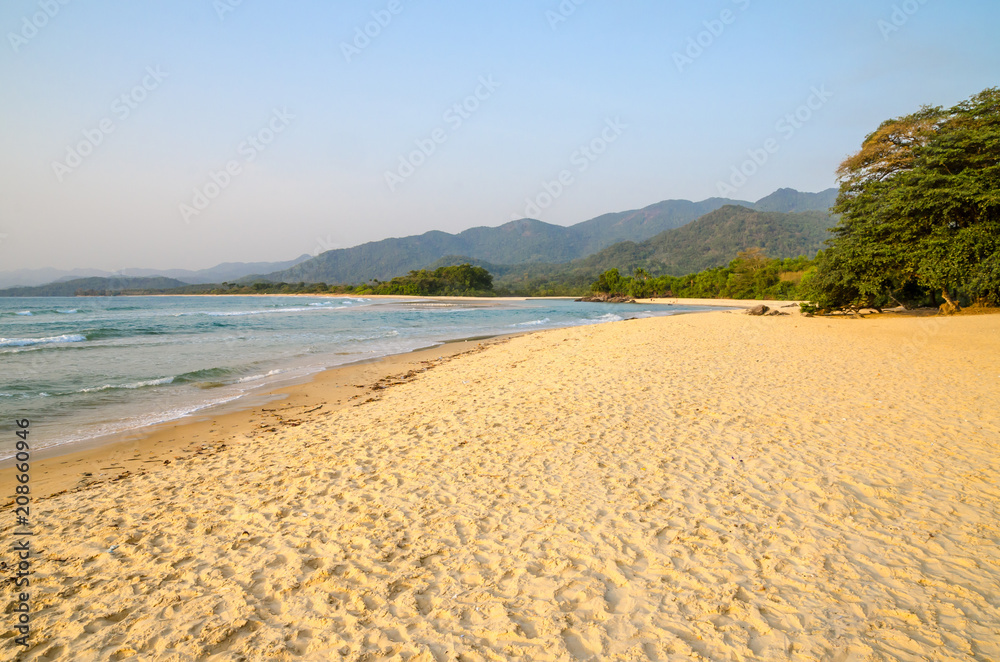 Beautiful Bureh Beach in the afternoon with yellow sand, green trees, sea and mountains, Sierra Leone, Africa Beautiful Bureh Beach in the afternoon with yellow sand, green trees, sea and mountains, Sierra Leone, Africa