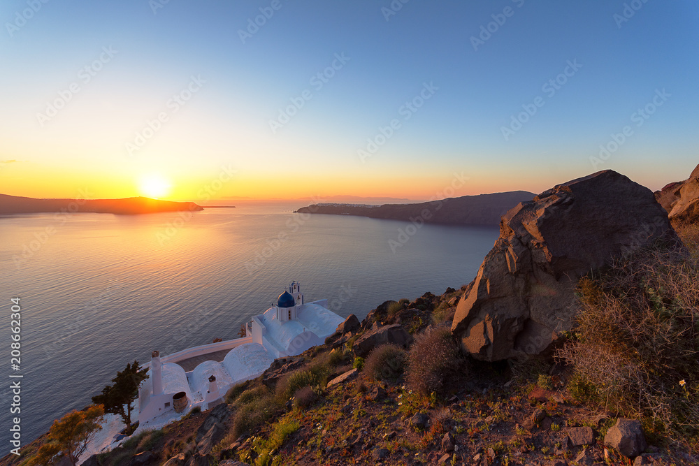 Amazing sunset at Panagia Theoskepasti, on the Skaros rock at Imerovigli, Santorini, Crete, Greece.