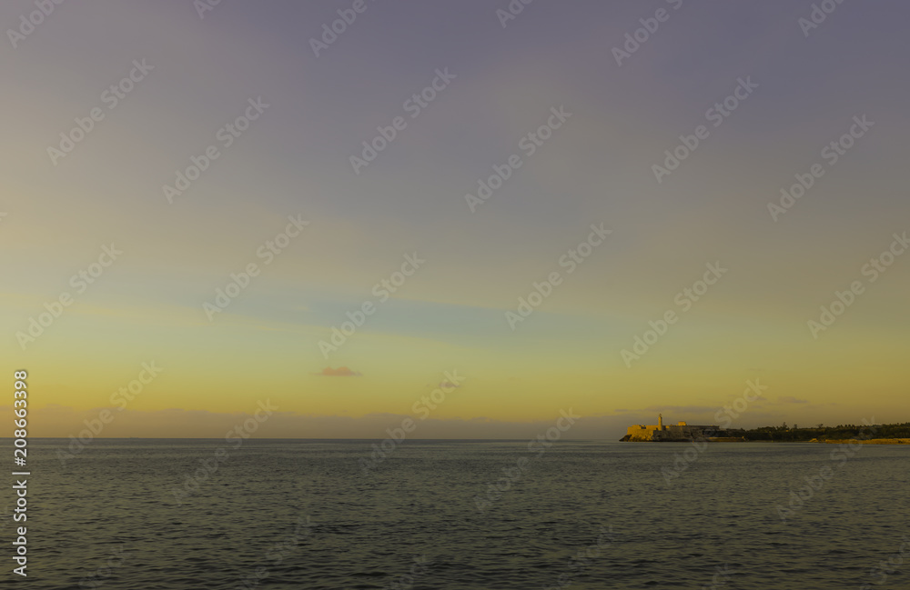 Sunset over Malecon and Atlantic Ocean with Morro Castle in background - Havana, Cuba 