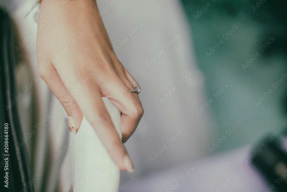 A beautiful diamond ring is worn at the finger of the bride's left hand.