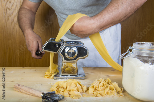 Chef de cocina italiano haciendo pasta fresca con una máquina sus manos  para cocinar comida tradicional Stock Photo