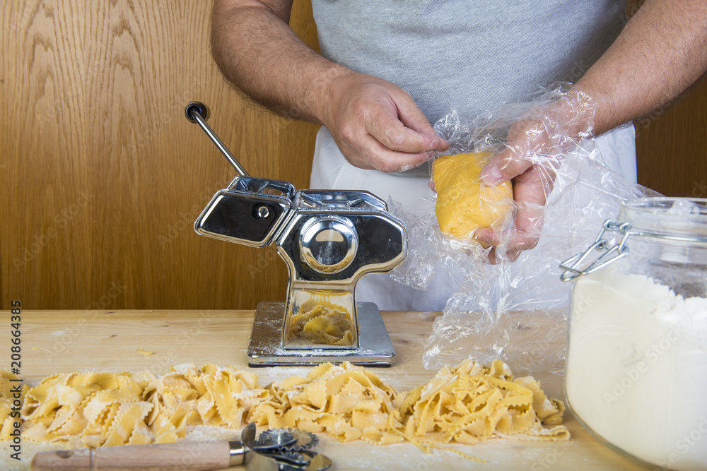 Chef de cocina italiano haciendo pasta fresca con una máquina sus manos  para cocinar comida tradicional Stock Photo