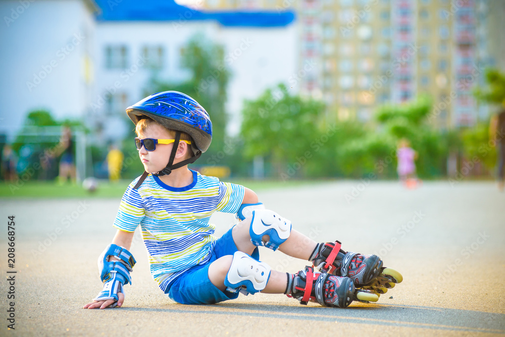 Happy boy in a protective helmet and protective pads for roller skating. Space for text Happy boy in a protective helmet and protective pads for roller skating. Space for text