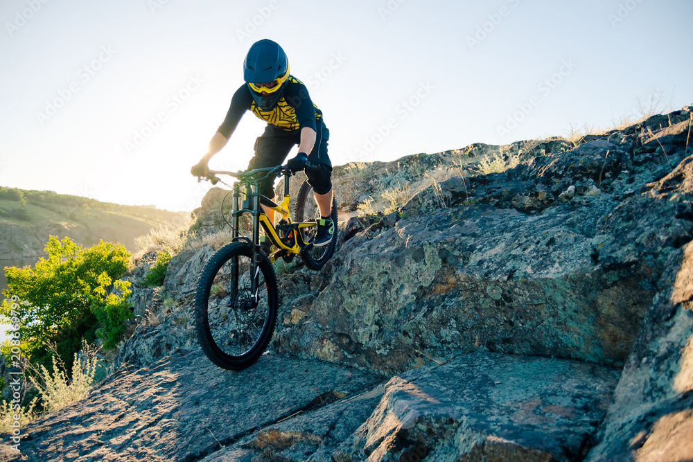 Cyclist Riding the Mountain Bike on the Summer Rocky Trail at the Evening. Extreme Sport and Enduro Cycling Concept.