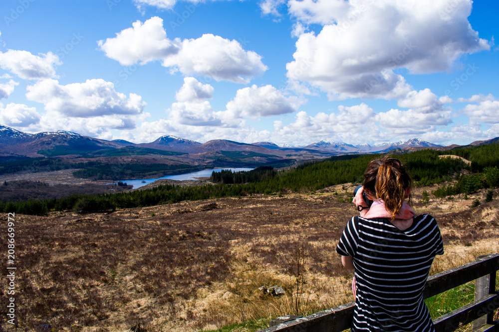 A woman photographer taking a photo of a landscape