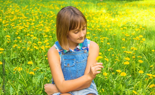 Portrait of a cute teenage girl with a yellow dandelion in her hand