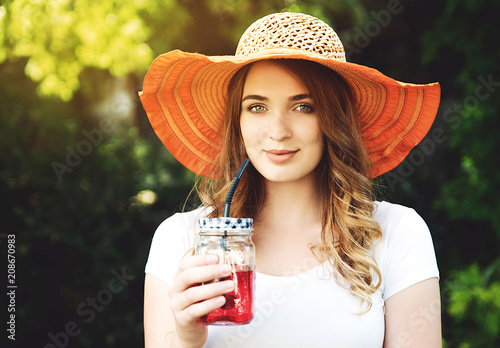 Young smiling woman holding jar with juice