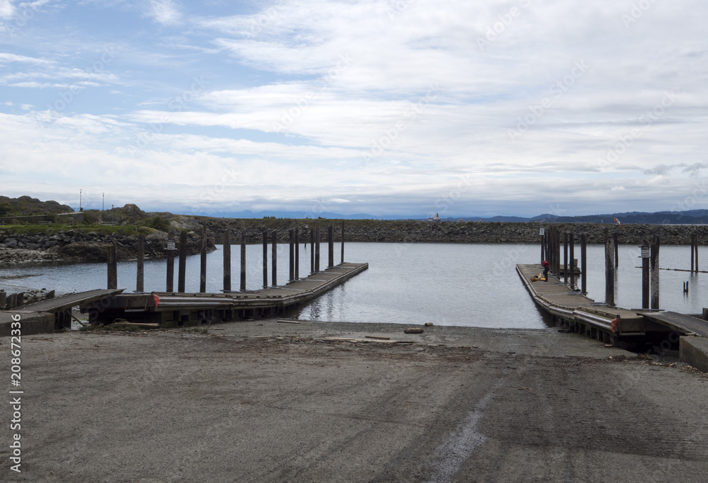 Public boat launch jetty into the ocean in a park on a summer day 