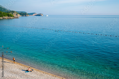 MONTENEGRO, KAMENOVO - JUNE 05/2017: tourists swim in the Adriatic Sea during sunset.