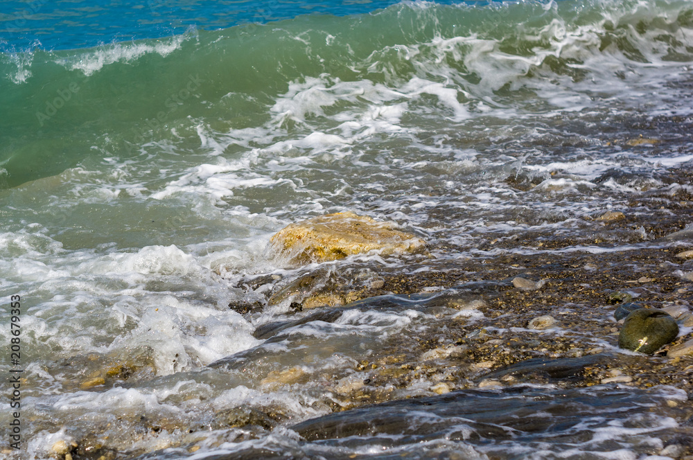 pebble stones on the sea beach, the rolling waves of the sea with foam pebble stones on the sea beach, the rolling waves of the sea with foam