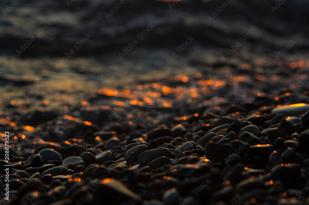 Fototapeta premium pebble stones on the sea beach, the rolling waves of the sea with foam