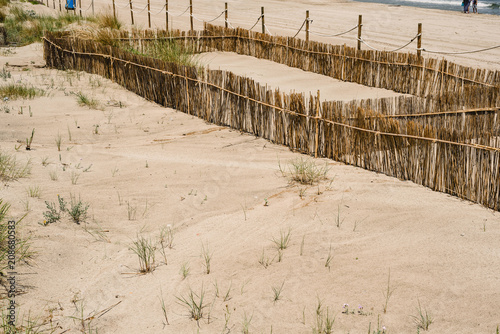 Fototapeta Naklejka Na Ścianę i Meble -  Fence to retain sand and create dunes on the beaches of Valencia