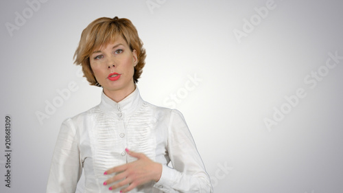 Businesswoman talking to camera on white background