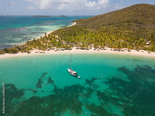 Aerial view of Mayreau beach in St-Vincent and the Grenadines - Tobago Cays. The paradise beach with palm trees and white sand beach