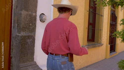 Caucasian man in a cowboy hat walking and playing with a balero photo