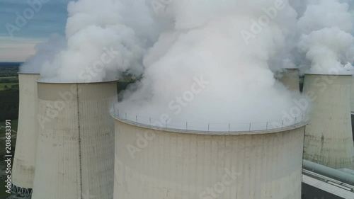 Drone shot flying past smoke billowing from cooling towers of coal fired power station factory in Germany, pollution and electricity generation Europe