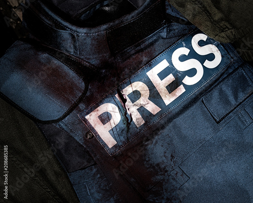 Cuadro en lienzo Photo of a press journalist armor war protective vest in blood splatter depicting mass media war victims