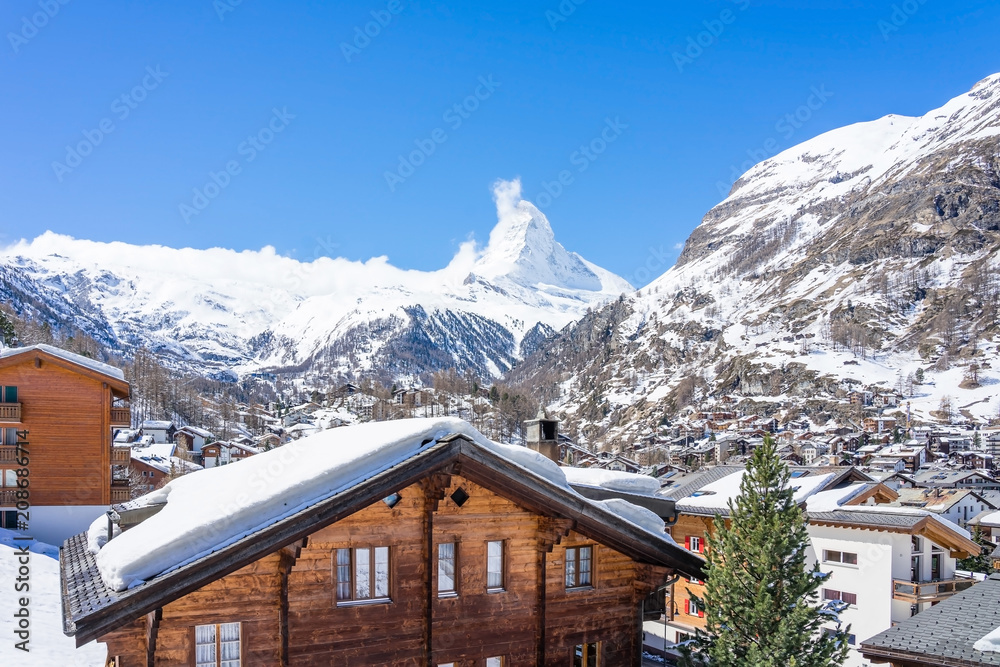 Fototapeta premium Beautiful view of old village in sunny day with Matterhorn peak background in Zermatt, Switzerland.