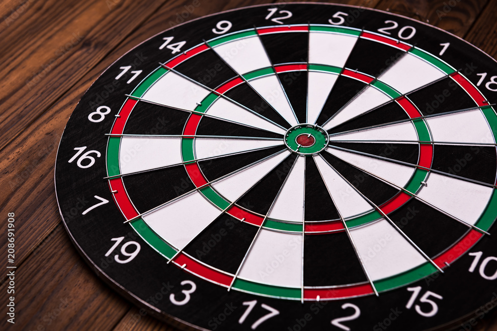 Darts board. Target on wooden table background. Darts board. Target on wooden table background.