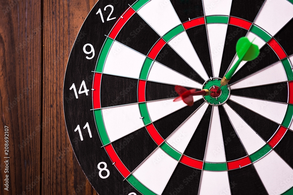 Darts hitting target. Two darts and target