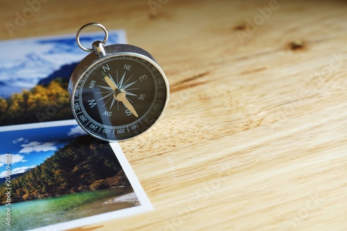 Compass on blur nature photograph of popular tourist destination in autumn background, China traveling concept