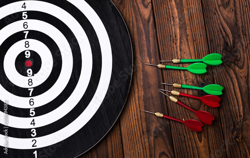 The darts on dark wooden background photo