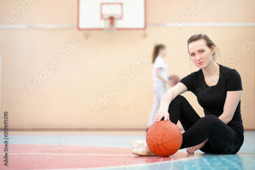 Girl in the gym playing a basketball