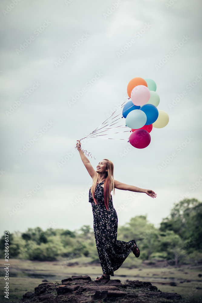 Young woman hand holding colorful balloons