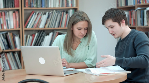 High school student working in library after classes, using laptop