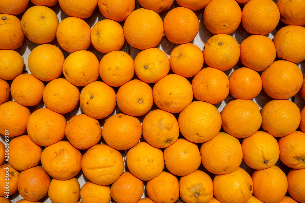 Rows of fresh natural organic orange fruit background in orange color and marked skin texture selling in fruit juice shop, Cappadocia