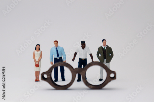 A concept of diversity and prejudice. Various miniature people standing behind the glasses.